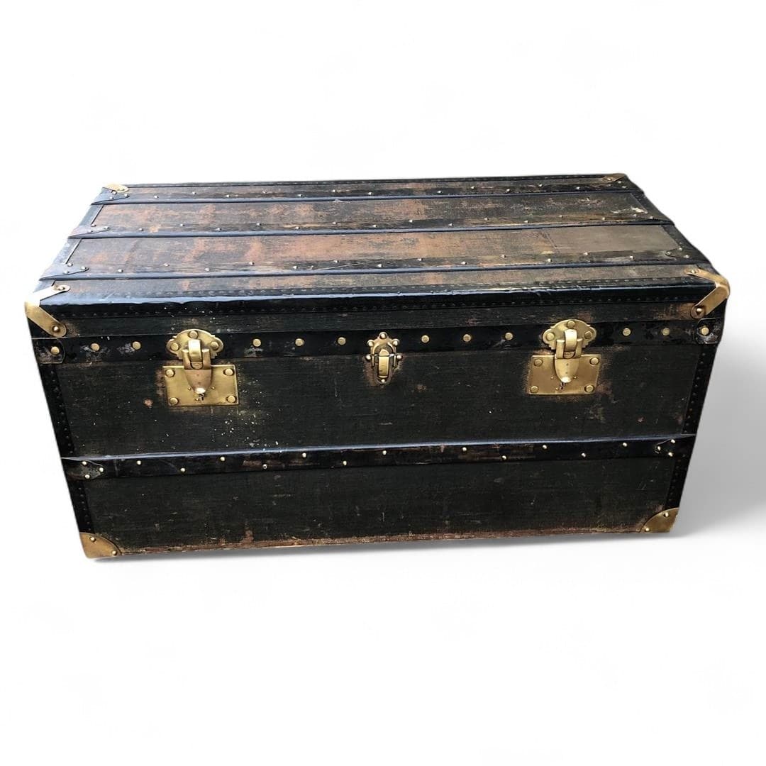 Antique wooden steamer trunk with dark fabric covering and leather handles